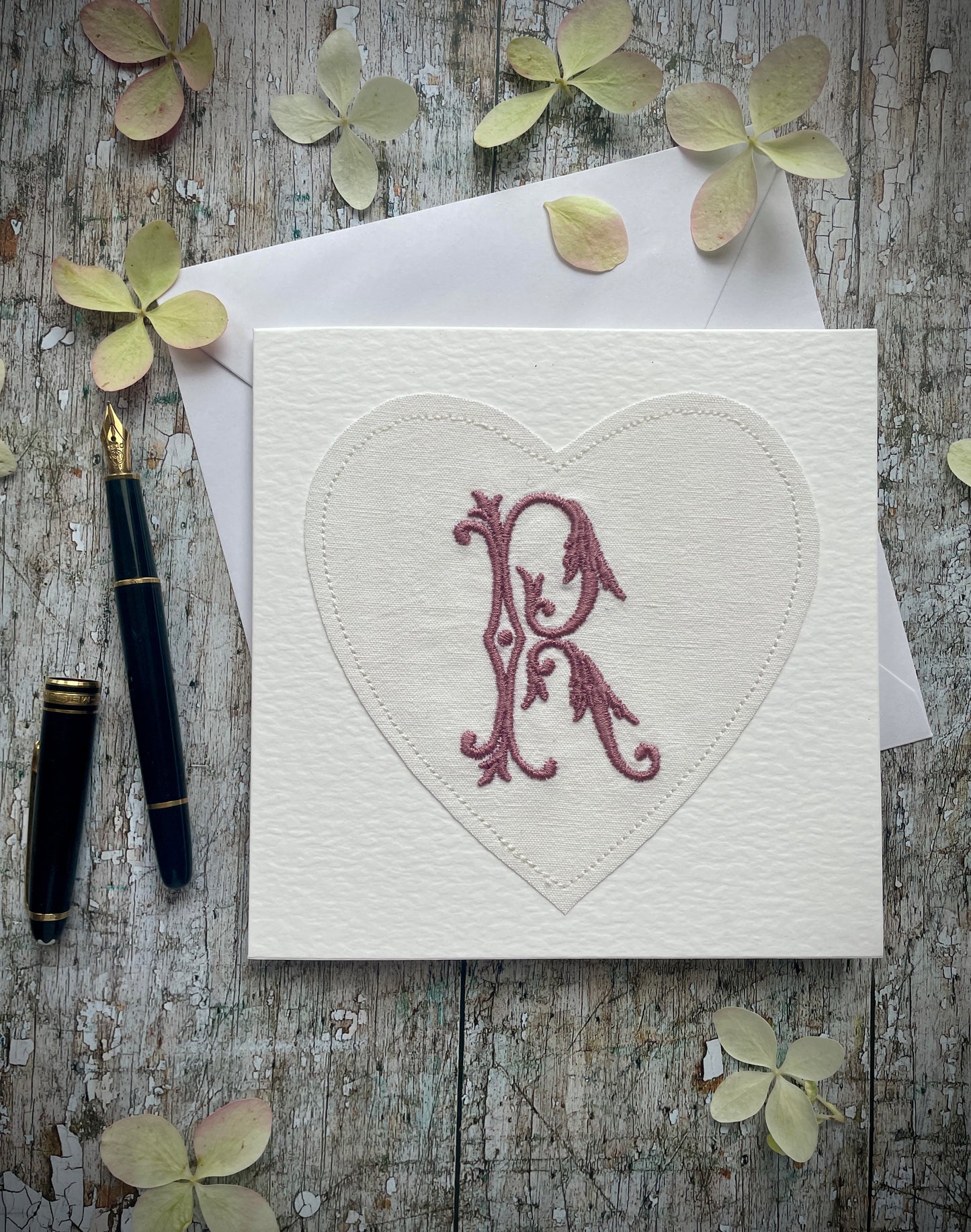 Embroidered Initial Card Mulberry R
Beautifully made one of a kind romantic card suitable for any occasion, or just to frame. The initial R has been embroidered with mulberry colour thread onto a piece of heart shaped vintage linen, then sewn onto a good quality acid free white 225 gsm hammered card, the inside left blank for your own special message. It comes with a simple white envelope in a cello bag.
Size: 6" x 6" / 15cm x 15cm