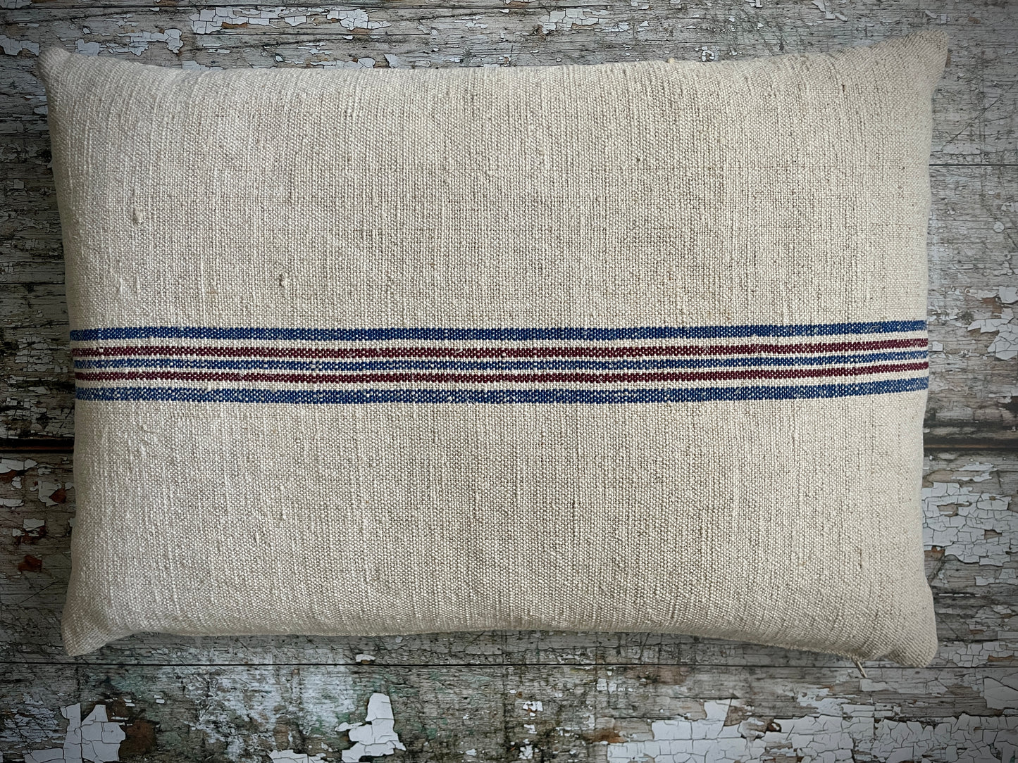 Vintage Hemp Grain Sack Cushion
Made by: Karen - vintage on the coast
This cream coloured hemp cushion has a wonderful slub texture and has been beautifully made from a vintage hemp grain sack with woven horizontal lines on both sides in blue and maroon. The cushion is filled with a plump feather pad and has a zip closure.
Size approximately:: 50 cm X 134 cm / 19+1/2" X 13+1/2".