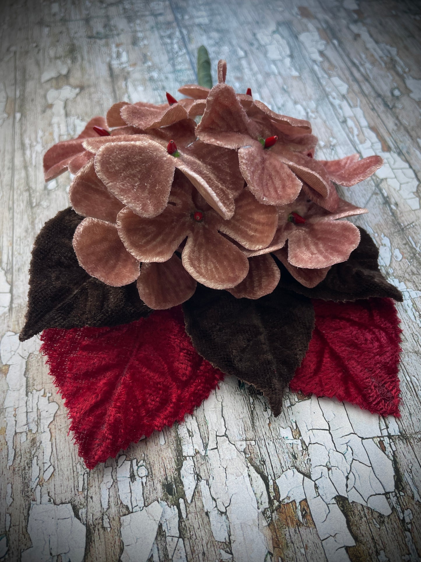 Dusky Pink Flowers + Red + Brown Leaves Brooch

This brooch contains unused old stock vintage millinery flowers, therefore like all vintage and antique items they may show slight signs of age.
Perfect as a gift for a vintage fan, dressing up, costumes, display and photo props.

I have made this brooch with 10 dusky pink velvet flocked vintage millinery flowers, 2 red and 3 dark chocolate brown leaves which were custom made from vintage velvet and a silver tone pin back brooch with a revolver safety catch. 
