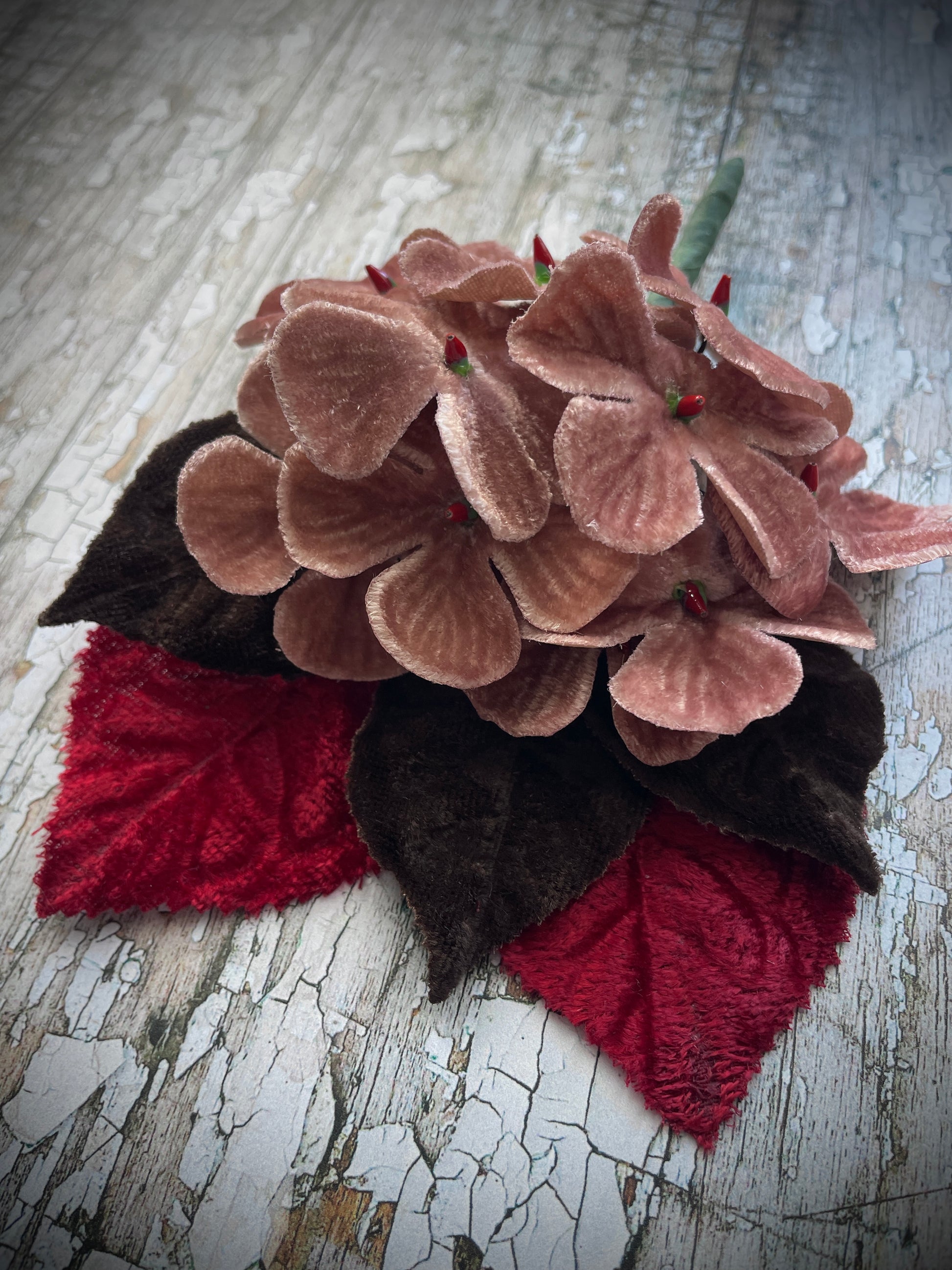 Dusky Pink Flowers + Red + Brown Leaves Brooch

This brooch contains unused old stock vintage millinery flowers, therefore like all vintage and antique items they may show slight signs of age.
Perfect as a gift for a vintage fan, dressing up, costumes, display and photo props.

I have made this brooch with 10 dusky pink velvet flocked vintage millinery flowers, 2 red and 3 dark chocolate brown leaves which were custom made from vintage velvet and a silver tone pin back brooch with a revolver safety catch. T