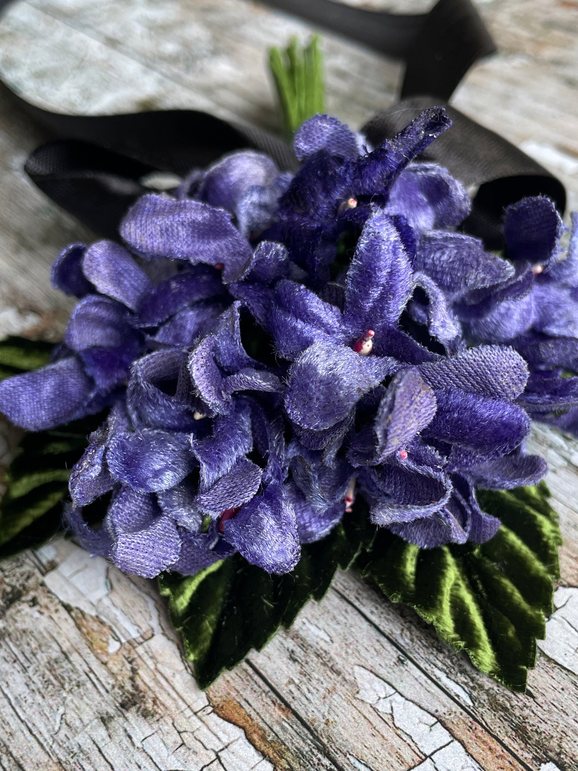Lavender Violets + Green Leaves
This brooch contains unused vintage millinery flowers.
Perfect as a gift for a vintage fan, dressing up, display or photo props.

Measurements Approximately:
Width: 12.5 cm / 5"
Length: 16 .5 cm / 6 + 1/2"
I have made this brooch with 23 vintage velvet violet flowers with 5 green velvet flocked leaves and a silver tone pin back brooch with a revolver safety catch, tied with a black satin ribbon. The corsage will arrive prettily packaged in a re-usable gift box to protect it.
