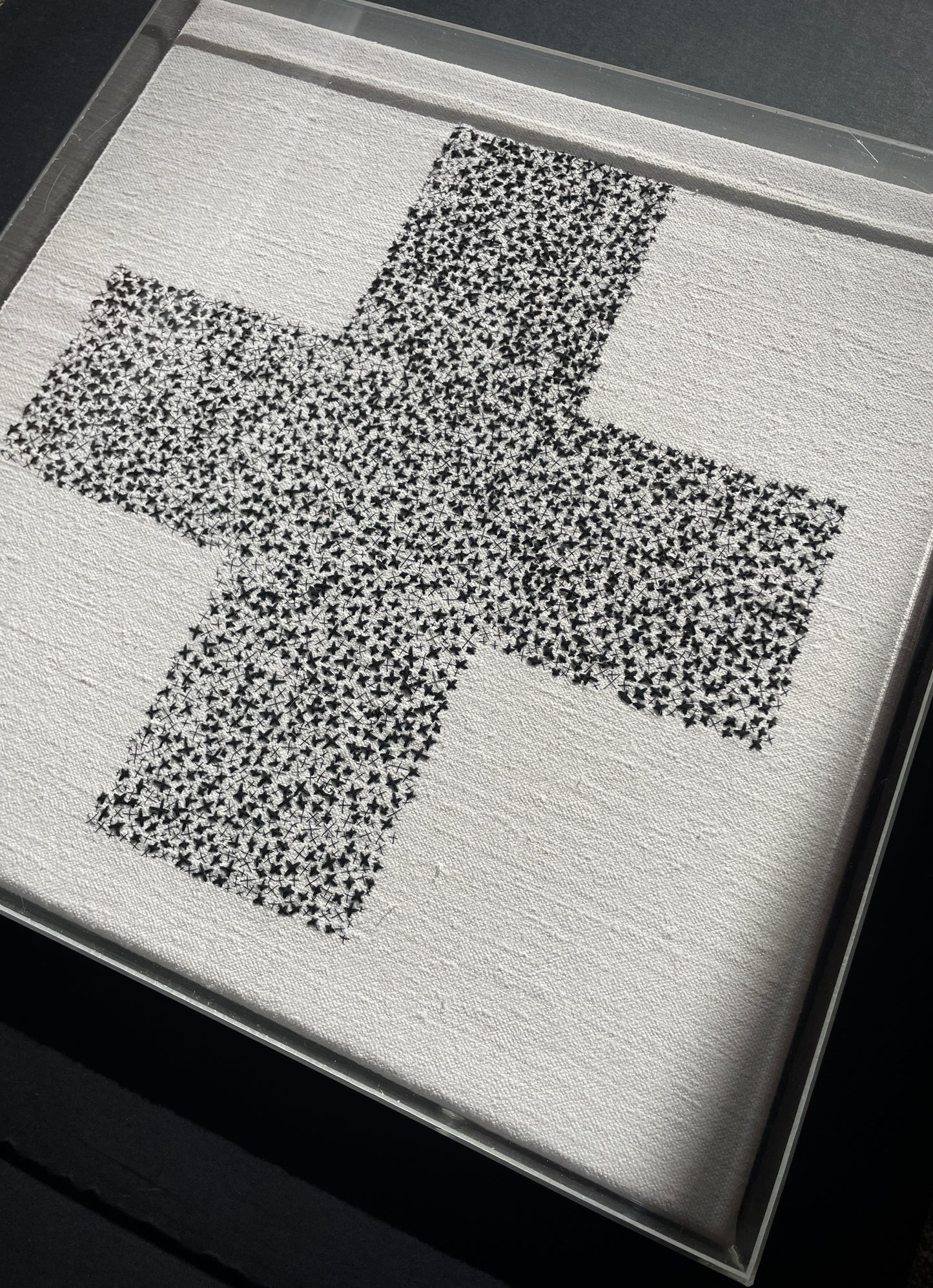Framed Embroidered Cross In Acrylic Tray
This is a one of a kind hand embroidered artwork, made by stitching hundreds of different sized crosses, with 3 different thicknesses of black linen and cotton thread, onto a beautiful vintage French slubbed linen.
The artwork was stretched over a wooden frame, then covered with a bespoke 3mm clear cast Acrylic tray, the back is open and strung ready to hang.
Size of frame approximately: 40.5 cm square / 16" square.
Depth of frame approximately: 4.5 cm / 3+1/4".