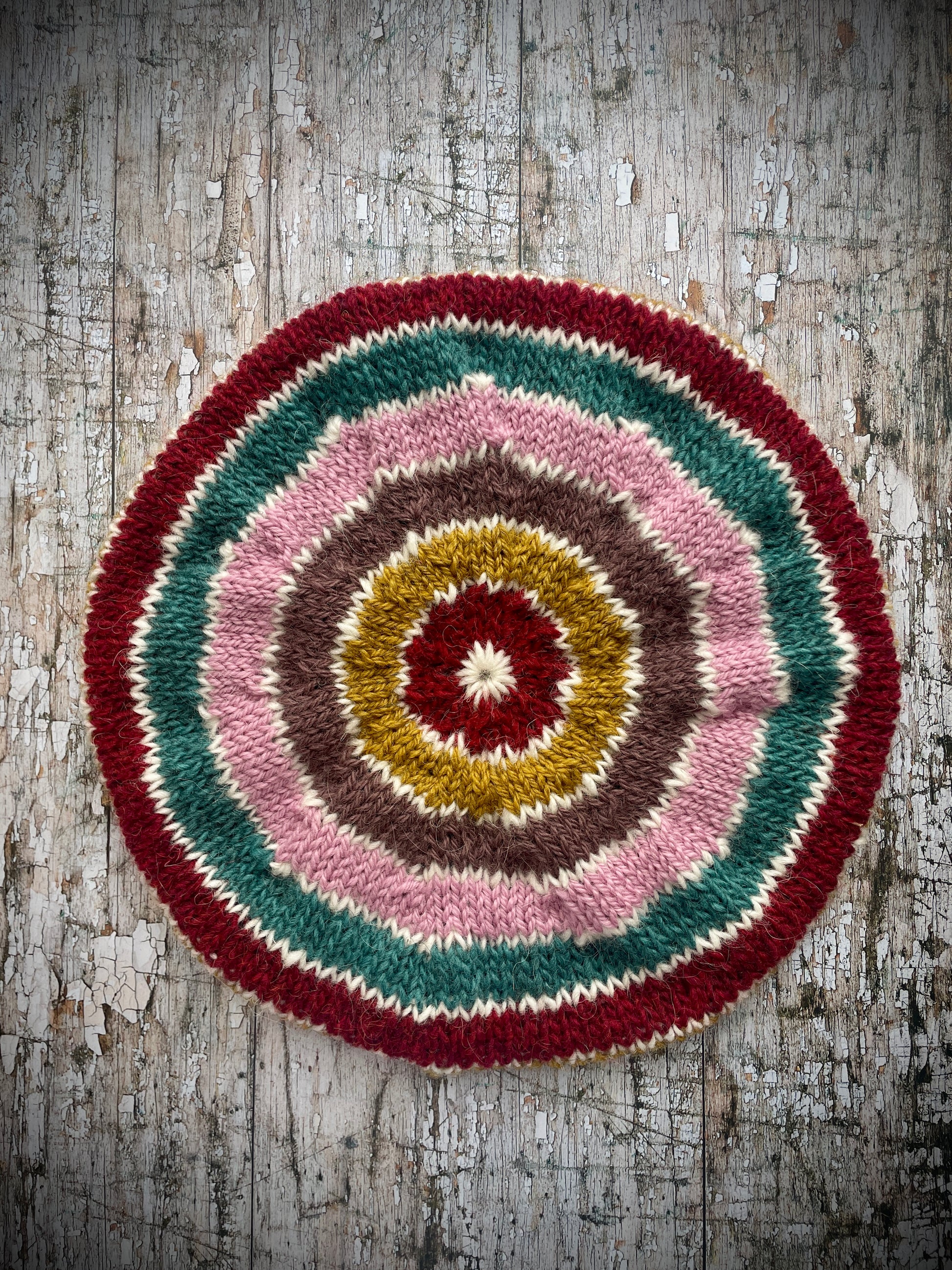 STRIPED PURE WOOL BERET

Beautifully hand knitted striped beret in a mixture of Icelandic, British and Peruvian pure wools, perfect for keeping your head warm on cold days. Knitted in viridian, white, rose, umber,, kelp and garnet with a ribbed band that gives the hat a snug fit.