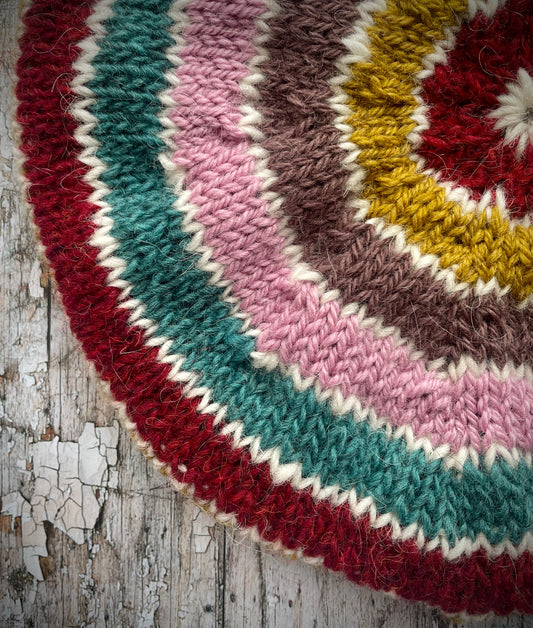 STRIPED PURE WOOL BERET

Beautifully hand knitted striped beret in a mixture of Icelandic, British and Peruvian pure wools, perfect for keeping your head warm on cold days. Knitted in viridian, white, rose, umber,, kelp and garnet with a ribbed band that gives the hat a snug fit.