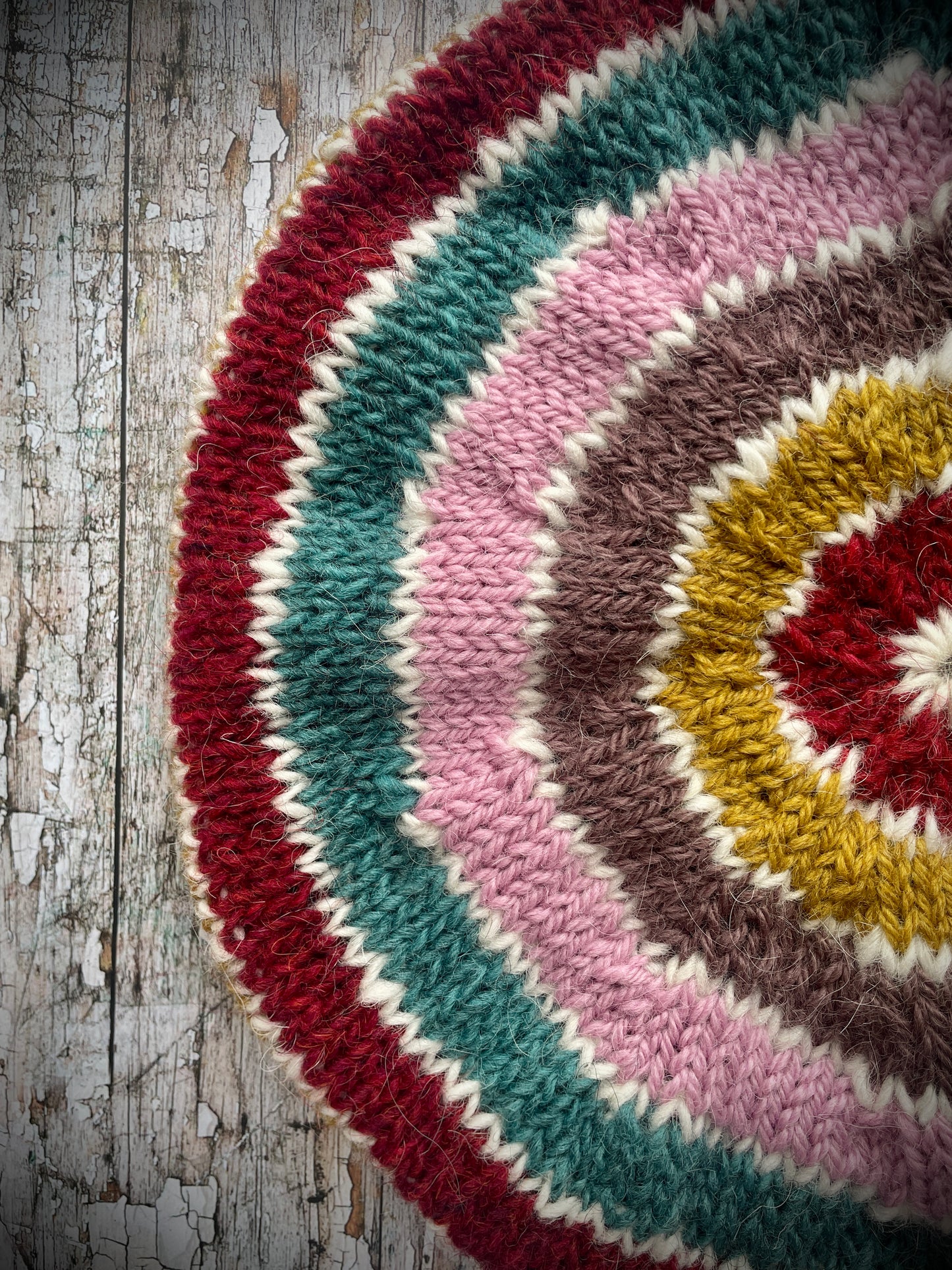STRIPED PURE WOOL BERET

Beautifully hand knitted striped beret in a mixture of Icelandic, British and Peruvian pure wools, perfect for keeping your head warm on cold days. Knitted in viridian, white, rose, umber,, kelp and garnet with a ribbed band that gives the hat a snug fit.