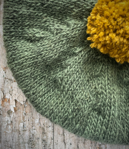Beautifully hand knitted beret in sage green heather Icelandic wool and a rich yellow BFL wool, perfect for keeping your head warm on cold days, with a ribbed band of sage green that gives the hat a snug fit.

SIZE: Adult.

CARE: hand wash or machine wash on wool cycle at 30 degrees, dry flat, do not tumble dry.