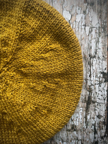 Beautifully hand knitted beret in a rich yellow BFL wool, perfect for keeping your head warm on cold days, with a ribbed band of sage green heather Icelandic wool that gives the hat a snug fit.

SIZE: small.

CARE: hand wash or machine wash on wool cycle at 30 degrees, dry flat, do not tumble dry.