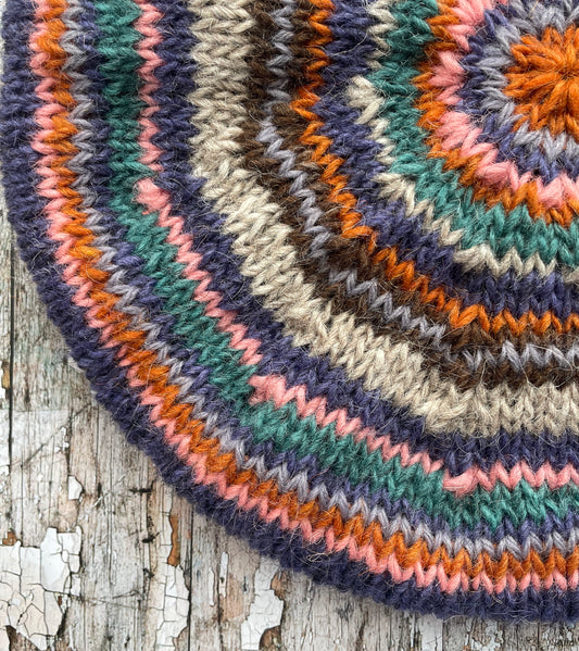 Beautifully hand knitted beret in Icelandic wool, perfect for keeping your head warm on cold days and adding a touch of 40's style to any outfit. Knitted in oat, viridian, violet, dark chocolate, mauve, pink and orange stripes, with an oat ribbed band that gives the hat a snug fit.

SIZE: adult.

CARE: hand wash or machine wash on wool cycle at 30 degrees, dry flat, do not tumble dry.