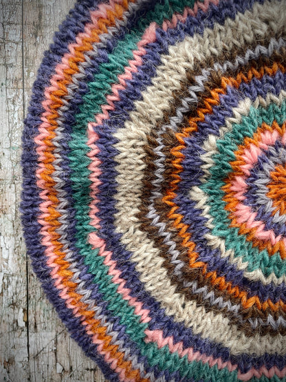 Beautifully hand knitted beret in Icelandic wool, perfect for keeping your head warm on cold days and adding a touch of 40's style to any outfit. Knitted in oat, viridian, violet, dark chocolate, mauve, pink and orange stripes, with an oat ribbed band that gives the hat a snug fit.

SIZE: adult.

CARE: hand wash or machine wash on wool cycle at 30 degrees, dry flat, do not tumble dry.