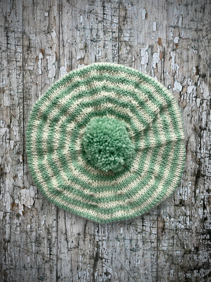 CHILDREN'S PISTACHIO + CREAM STRIPED WOOL BERET
Beautifully hand knitted beret in soft pure wool and merino wool, perfect for keeping little heads warm on cold days. Knitted in nautical Breton stripes of pistachio green and cream, with a big green pom and green ribbed band that gives the hat a snug fit. It would look lovely on boys or girls.

SIZE: child 6 - 24 mths.
Diameter approximately: 26cm / 10+1/4".
CARE: hand wash or machine wash on wool cycle at 30 degrees, dry flat, do not tumble dry.