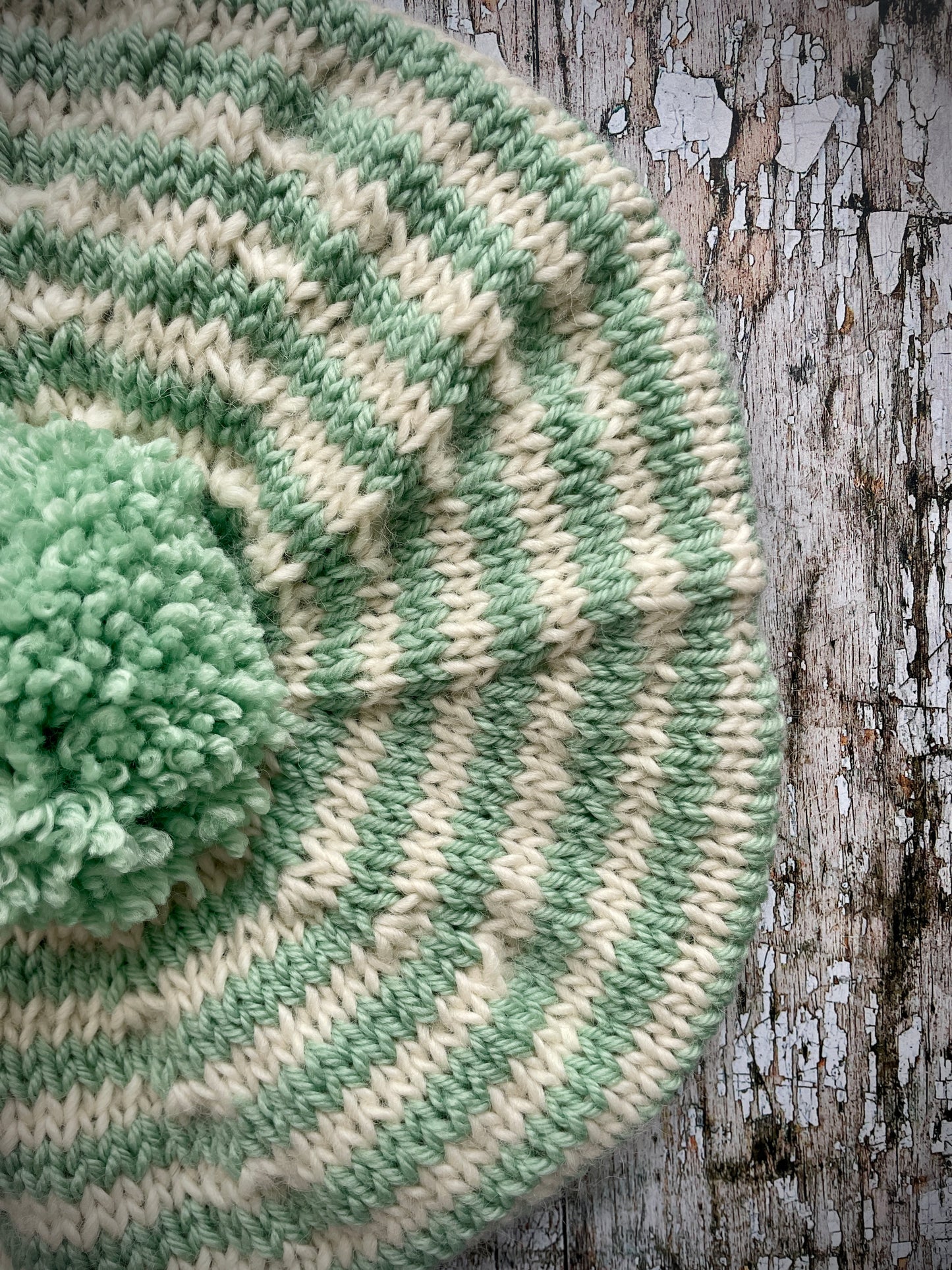 CHILDREN'S PISTACHIO + CREAM STRIPED WOOL BERET
Beautifully hand knitted beret in soft pure wool and merino wool, perfect for keeping little heads warm on cold days. Knitted in nautical Breton stripes of pistachio green and cream, with a big green pom and green ribbed band that gives the hat a snug fit. It would look lovely on boys or girls.

SIZE: child 6 - 24 mths.
Diameter approximately: 26cm / 10+1/4".
CARE: hand wash or machine wash on wool cycle at 30 degrees, dry flat, do not tumble dry.