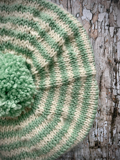 CHILDREN'S PISTACHIO + CREAM STRIPED WOOL BERET
Beautifully hand knitted beret in soft pure wool and merino wool, perfect for keeping little heads warm on cold days. Knitted in nautical Breton stripes of pistachio green and cream, with a big green pom and green ribbed band that gives the hat a snug fit. It would look lovely on boys or girls.

SIZE: child 6 - 24 mths.
Diameter approximately: 26cm / 10+1/4".
CARE: hand wash or machine wash on wool cycle at 30 degrees, dry flat, do not tumble dry.