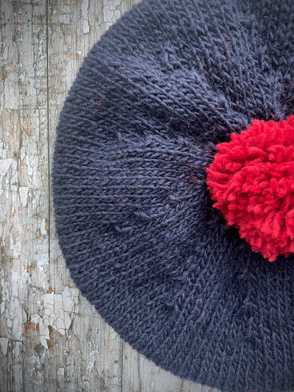 Hand Knitted Wool Beret Navy Blue + Red

Beautifully hand knitted beret in Icelandic pure wool, perfect for keeping your head warm on cold days. Knitted in a dark navy blue colour with a bright red pom and navy blue ribbed band that gives the hat a snug fit.

SIZE: adult.

CARE: hand wash or machine wash on wool cycle at 30 degrees, dry flat, do not tumble dry.