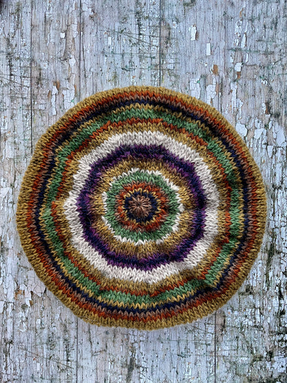 Beautifully hand knitted beret in Icelandic wool, perfect for keeping your head warm on cold days and adding a touch of 40's style to any outfit. Knitted in oat, sage green heather, dark kelp, violet heather, navy, burnt orange and milk chocolate stripes, with a green heather ribbed band that gives the hat a snug fit.

SIZE: adult.

CARE: hand wash or machine wash on wool cycle at 30 degrees, dry flat, do not tumble dry.