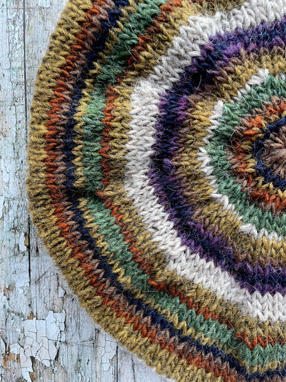 Beautifully hand knitted beret in Icelandic wool, perfect for keeping your head warm on cold days and adding a touch of 40's style to any outfit. Knitted in oat, sage green heather, dark kelp, violet heather, navy, burnt orange and milk chocolate stripes, with a green heather ribbed band that gives the hat a snug fit.

SIZE: adult.

CARE: hand wash or machine wash on wool cycle at 30 degrees, dry flat, do not tumble dry.