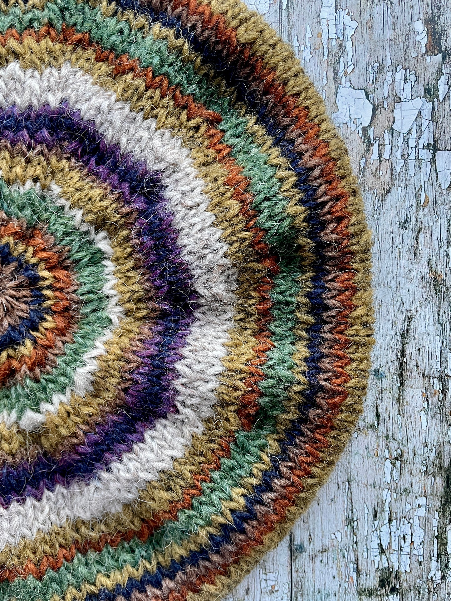 Beautifully hand knitted beret in Icelandic wool, perfect for keeping your head warm on cold days and adding a touch of 40's style to any outfit. Knitted in oat, sage green heather, dark kelp, violet heather, navy, burnt orange and milk chocolate stripes, with a green heather ribbed band that gives the hat a snug fit.

SIZE: adult.

CARE: hand wash or machine wash on wool cycle at 30 degrees, dry flat, do not tumble dry.