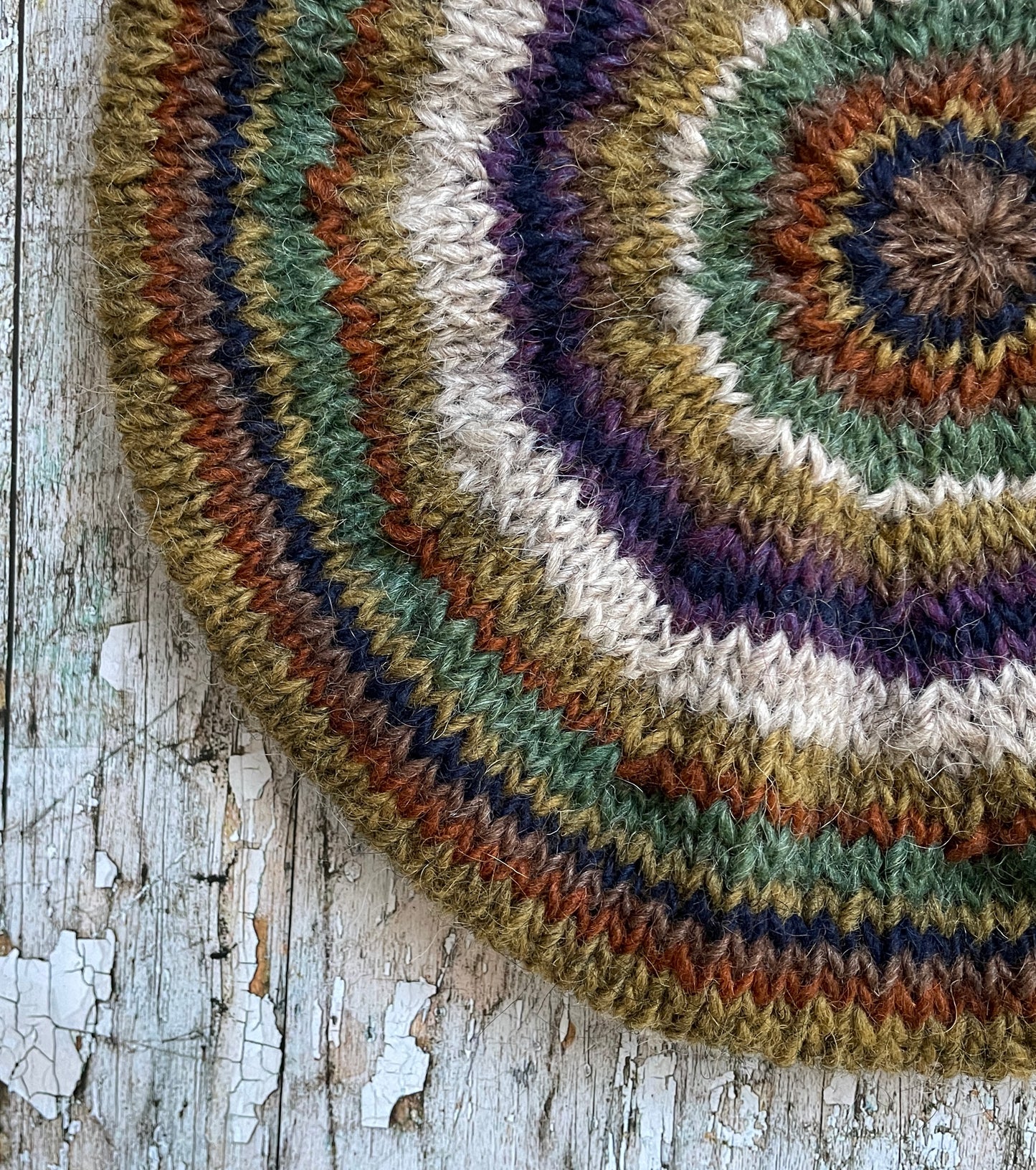 Beautifully hand knitted beret in Icelandic wool, perfect for keeping your head warm on cold days and adding a touch of 40's style to any outfit. Knitted in oat, sage green heather, dark kelp, violet heather, navy, burnt orange and milk chocolate stripes, with a green heather ribbed band that gives the hat a snug fit.

SIZE: adult.

CARE: hand wash or machine wash on wool cycle at 30 degrees, dry flat, do not tumble dry.