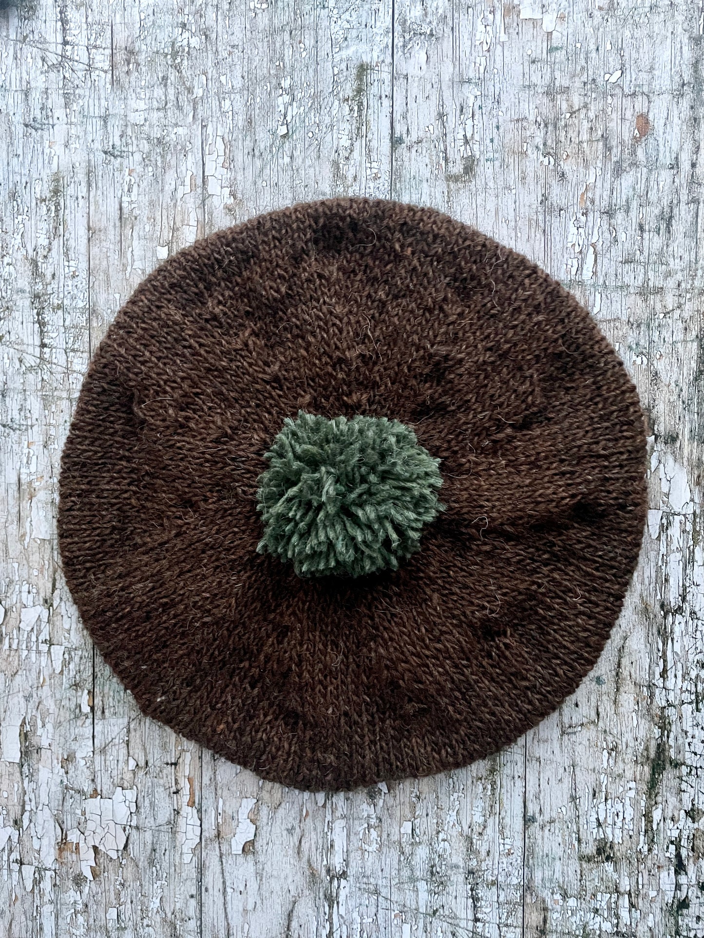 Hand Knitted Wool Beret Dark Chocolate + Sage Green Heather

Beautifully hand knitted beret in Icelandic pure wool, perfect for keeping your head warm on cold days. Knitted in a lovely dark chocolate brown colour with a sage green pom and ribbed band that gives the hat a snug fit.

SIZE: adult.

CARE: hand wash or machine wash on wool cycle at 30 degrees, dry flat, do not tumble dry.