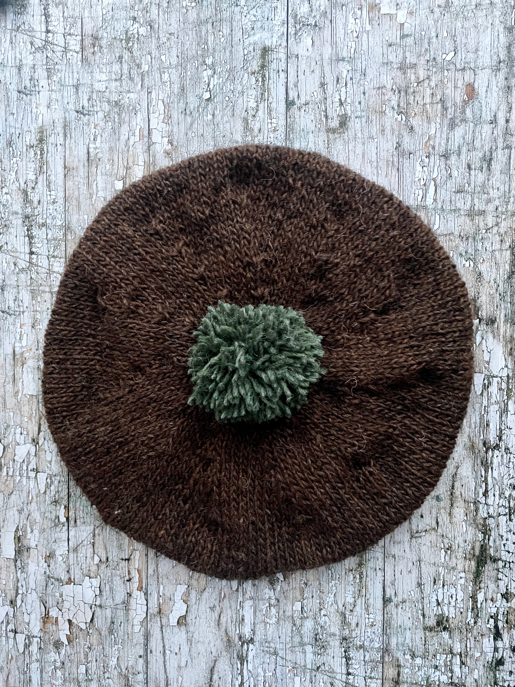 Hand Knitted Wool Beret Dark Chocolate + Sage Green Heather

Beautifully hand knitted beret in Icelandic pure wool, perfect for keeping your head warm on cold days. Knitted in a lovely dark chocolate brown colour with a sage green pom and ribbed band that gives the hat a snug fit.

SIZE: adult.

CARE: hand wash or machine wash on wool cycle at 30 degrees, dry flat, do not tumble dry.
