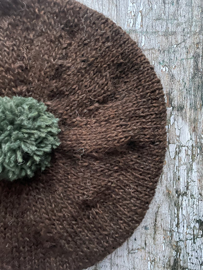 Hand Knitted Wool Beret Dark Chocolate + Sage Green Heather

Beautifully hand knitted beret in Icelandic pure wool, perfect for keeping your head warm on cold days. Knitted in a lovely dark chocolate brown colour with a sage green pom and ribbed band that gives the hat a snug fit.

SIZE: adult.

CARE: hand wash or machine wash on wool cycle at 30 degrees, dry flat, do not tumble dry.