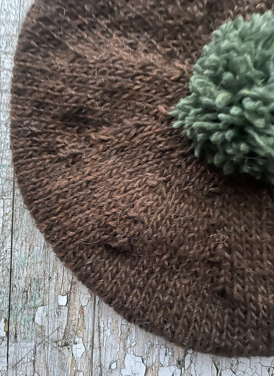 Hand Knitted Wool Beret Dark Chocolate + Sage Green Heather

Beautifully hand knitted beret in Icelandic pure wool, perfect for keeping your head warm on cold days. Knitted in a lovely dark chocolate brown colour with a sage green pom and ribbed band that gives the hat a snug fit.

SIZE: adult.

CARE: hand wash or machine wash on wool cycle at 30 degrees, dry flat, do not tumble dry.