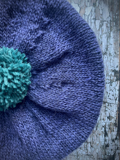 Hand Knitted Wool Lavender + Viridian Beret

Beautifully hand knitted beret in Icelandic pure wool, perfect for keeping your head warm on cold days. Knitted in a deep lavender, with a big viridian pom and a ribbed band that gives the hat a snug fit.

SIZE: adult.

CARE: hand wash or machine wash on wool cycle at 30 degrees, dry flat, do not tumble dry.