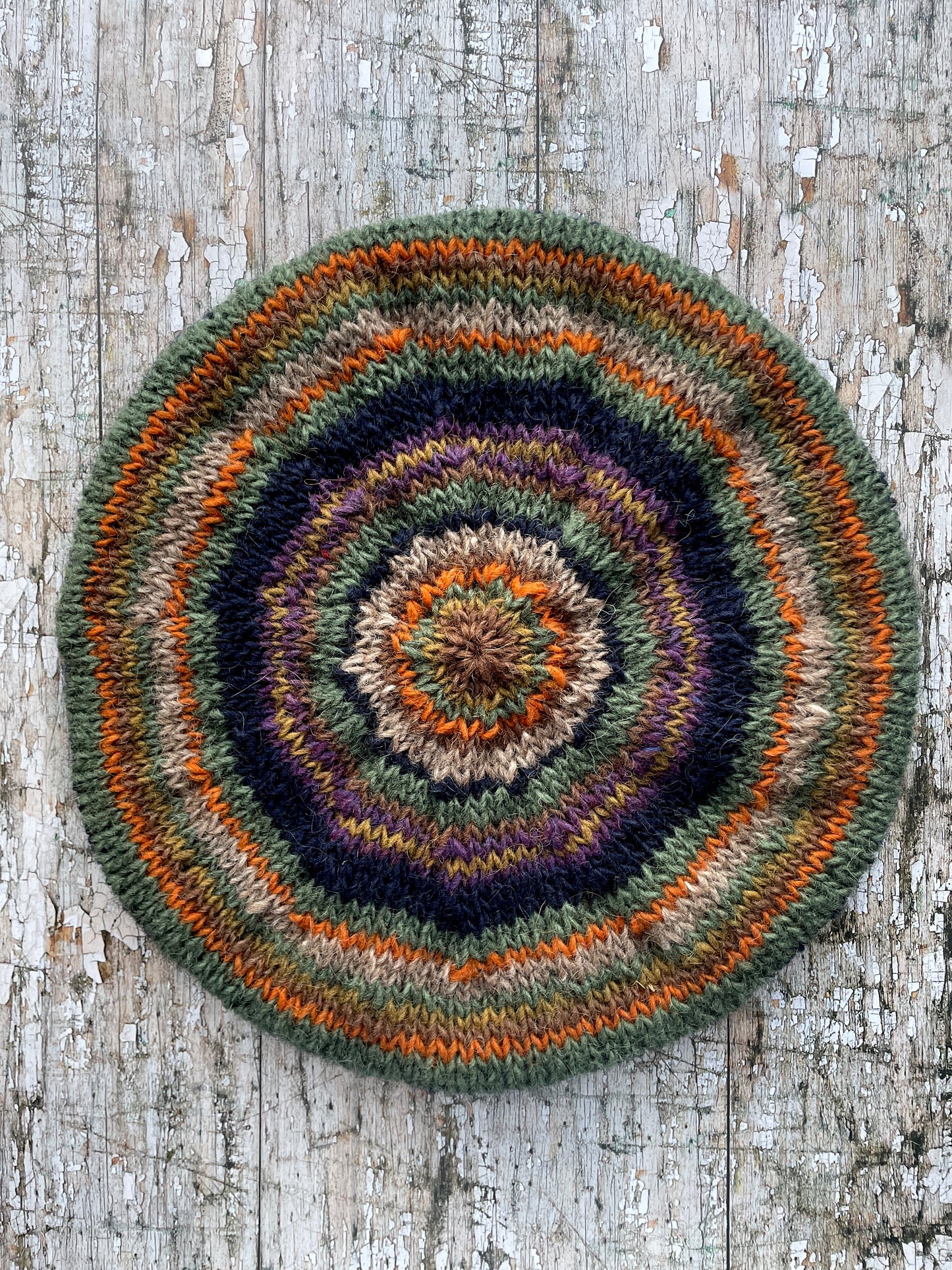 Beautifully hand knitted beret in Icelandic wool, perfect for keeping your head warm on cold days and adding a touch of 40's style to any outfit. Knitted in navy, dark oat, green heather, violet heather, kelp, burnt orange and milk chocolate stripes, with a navy ribbed band that gives the hat a snug fit.

SIZE: adult.

DIAMETER: 11+1/2" / 29cm.

CARE: hand wash or machine wash on wool cycle at 30 degrees, dry flat, do not tumble dry.