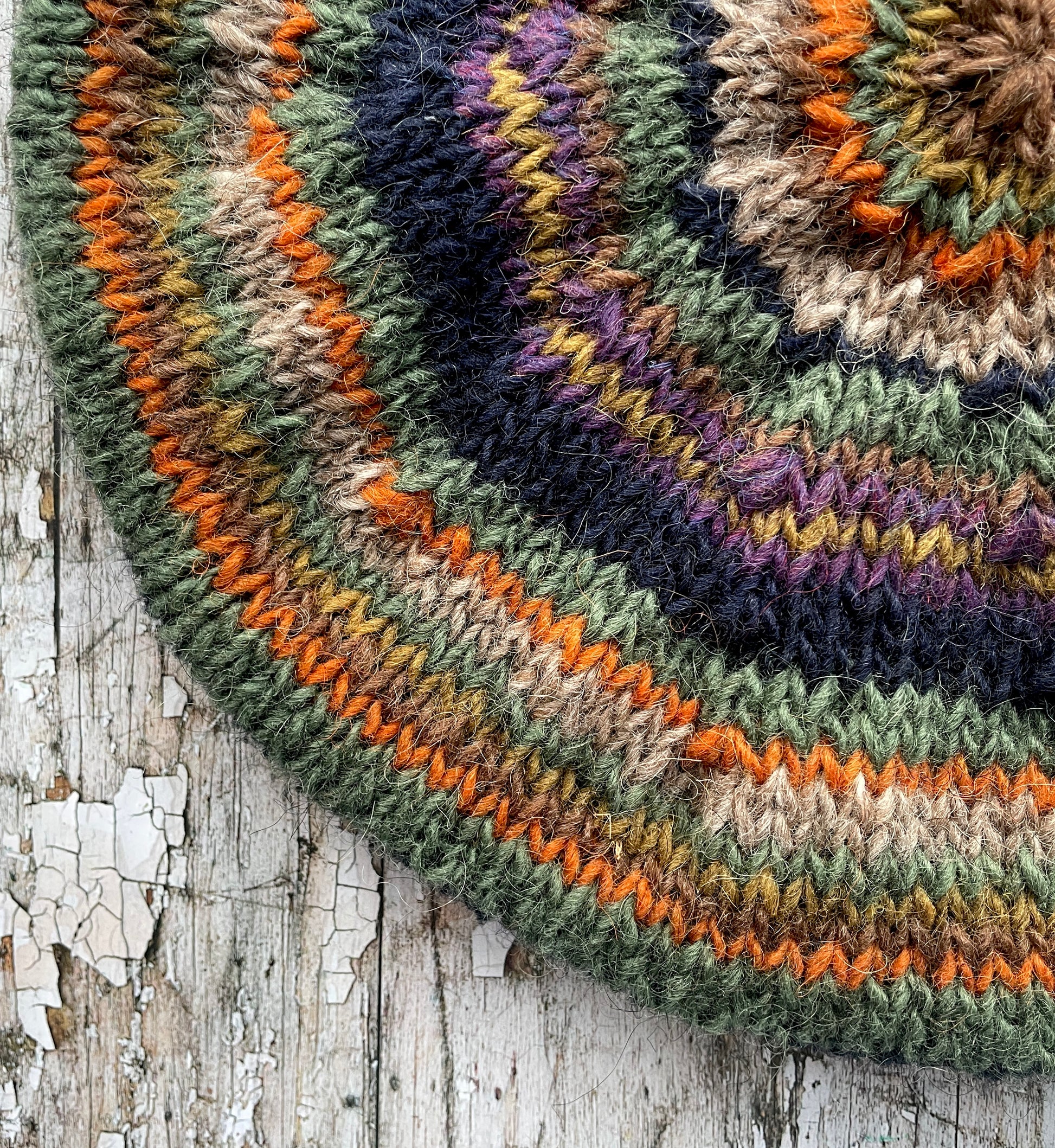 Beautifully hand knitted beret in Icelandic wool, perfect for keeping your head warm on cold days and adding a touch of 40's style to any outfit. Knitted in navy, dark oat, green heather, violet heather, kelp, burnt orange and milk chocolate stripes, with a navy ribbed band that gives the hat a snug fit.

SIZE: adult.

DIAMETER: 11+1/2" / 29cm.

CARE: hand wash or machine wash on wool cycle at 30 degrees, dry flat, do not tumble dry.