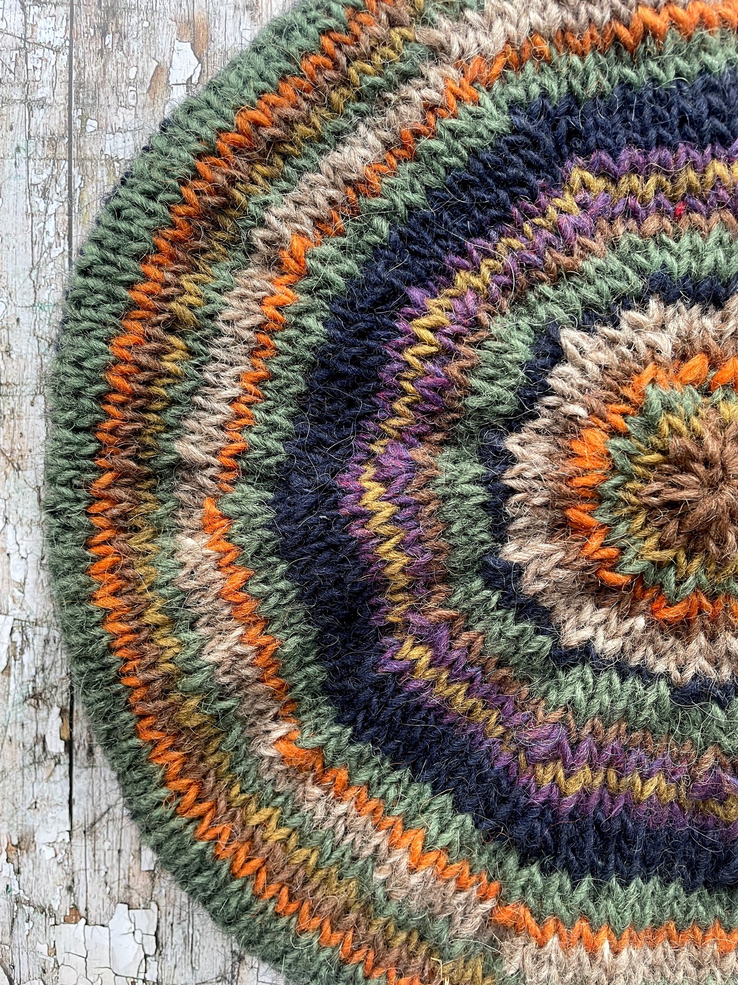 Beautifully hand knitted beret in Icelandic wool, perfect for keeping your head warm on cold days and adding a touch of 40's style to any outfit. Knitted in navy, dark oat, green heather, violet heather, kelp, burnt orange and milk chocolate stripes, with a navy ribbed band that gives the hat a snug fit.

SIZE: adult.

DIAMETER: 11+1/2" / 29cm.

CARE: hand wash or machine wash on wool cycle at 30 degrees, dry flat, do not tumble dry.