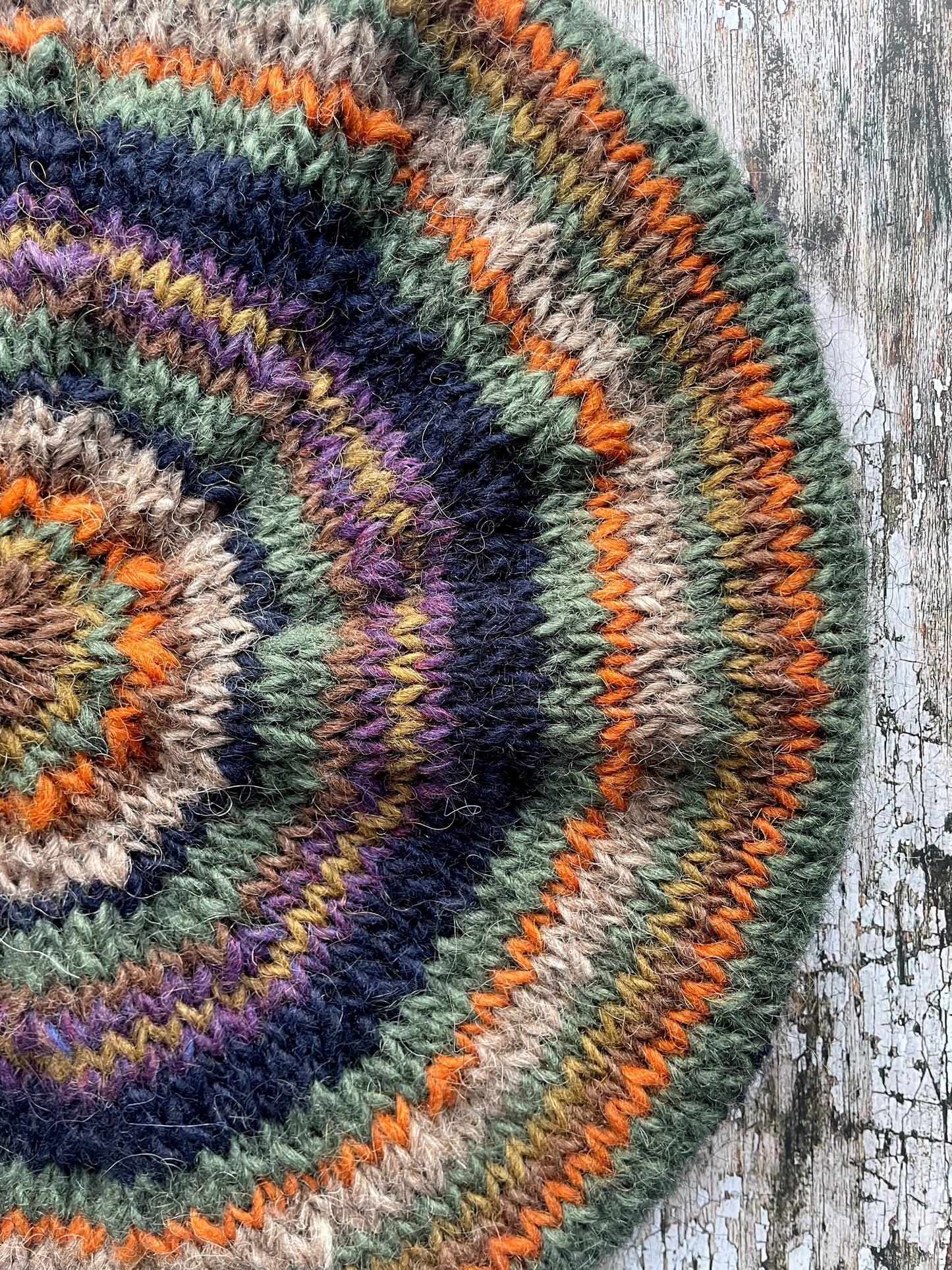 Beautifully hand knitted beret in Icelandic wool, perfect for keeping your head warm on cold days and adding a touch of 40's style to any outfit. Knitted in navy, dark oat, green heather, violet heather, kelp, burnt orange and milk chocolate stripes, with a navy ribbed band that gives the hat a snug fit.

SIZE: adult.

DIAMETER: 11+1/2" / 29cm.

CARE: hand wash or machine wash on wool cycle at 30 degrees, dry flat, do not tumble dry.