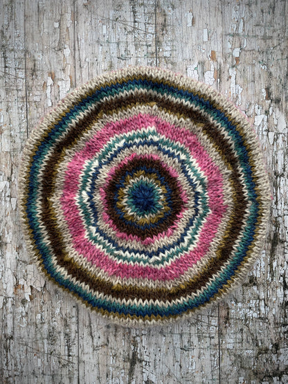 Classic 40's Style Beret no.5
Beautifully hand knitted beret in Icelandic wool, perfect for keeping your head warm on cold days and adding a touch of 40's style to any outfit. Knitted in pink heather, dark chocolate, oat, white, viridian, dark kelp and indigo stripes, with a pink heather ribbed band that gives the hat a snug fit.

SIZE: adult.

DIAMETER: 11+1/4" / 28.5cm.&nbsp;

CARE: hand wash or machine wash on wool cycle at 30 degrees, dry flat, do not tumble dry.