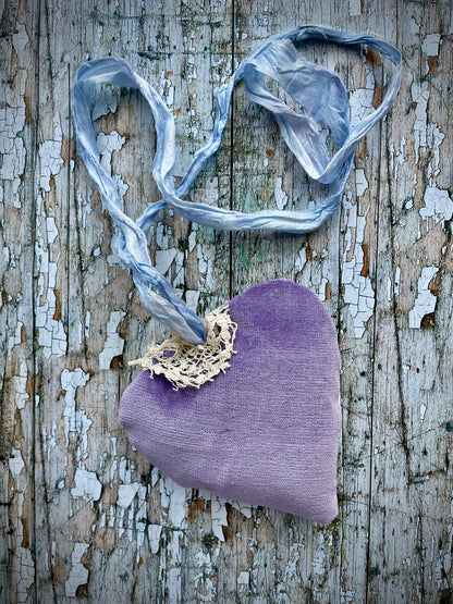 A beautiful one of a kind heart... made by hand stitching together vintage embroidered linen of pink, mauve, lavender and blue flowers, with vintage cream lace, linen flowers and a blue velvet leaf embellished with small silver bugle beads. The back is made of pale lavender velvet and the heart hangs with a loop of blue raw edged sari silk to wear around the neck or hang on the wall as a decoration. The inside of the heart has been gently filled with non-allergenic filling conforming to BS + CE  standards.
