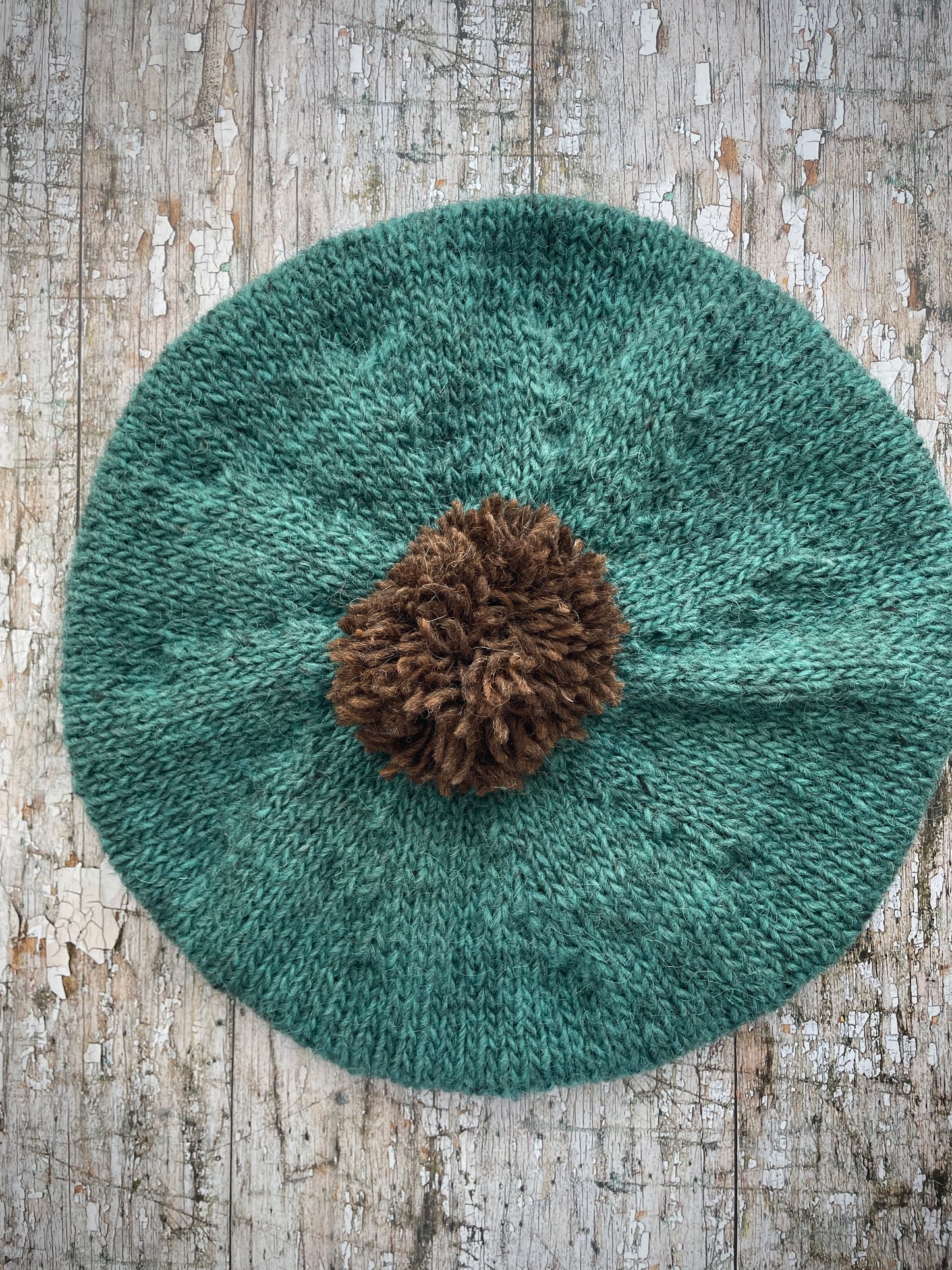 Hand Knitted Wool Beret Viridian + Dark Chocolate Brown

Beautifully hand knitted beret in Icelandic pure wool, perfect for keeping your head warm on cold days. Knitted in a lovely viridian colour with a dark chocolate brown pom and ribbed band that gives the hat a snug fit.

SIZE: adult.

DIAMETER: 11+1/4" / 28.5cm.

CARE: hand wash or machine wash on wool cycle at 30 degrees, dry flat, do not tumble dry.