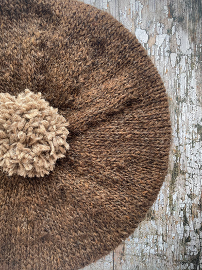 Hand Knitted Wool Beret Dark Chocolate + Dark Oat

Beautifully hand knitted beret in Icelandic pure wool, perfect for keeping your head warm on cold days. Knitted in a lovely dark chocolate brown colour with a dark oat pom and ribbed band that gives the hat a snug fit.

SIZE: adult.

DIAMETER: 11+1/2" / 29cm.

CARE: hand wash or machine wash on wool cycle at 30 degrees, dry flat, do not tumble dry.