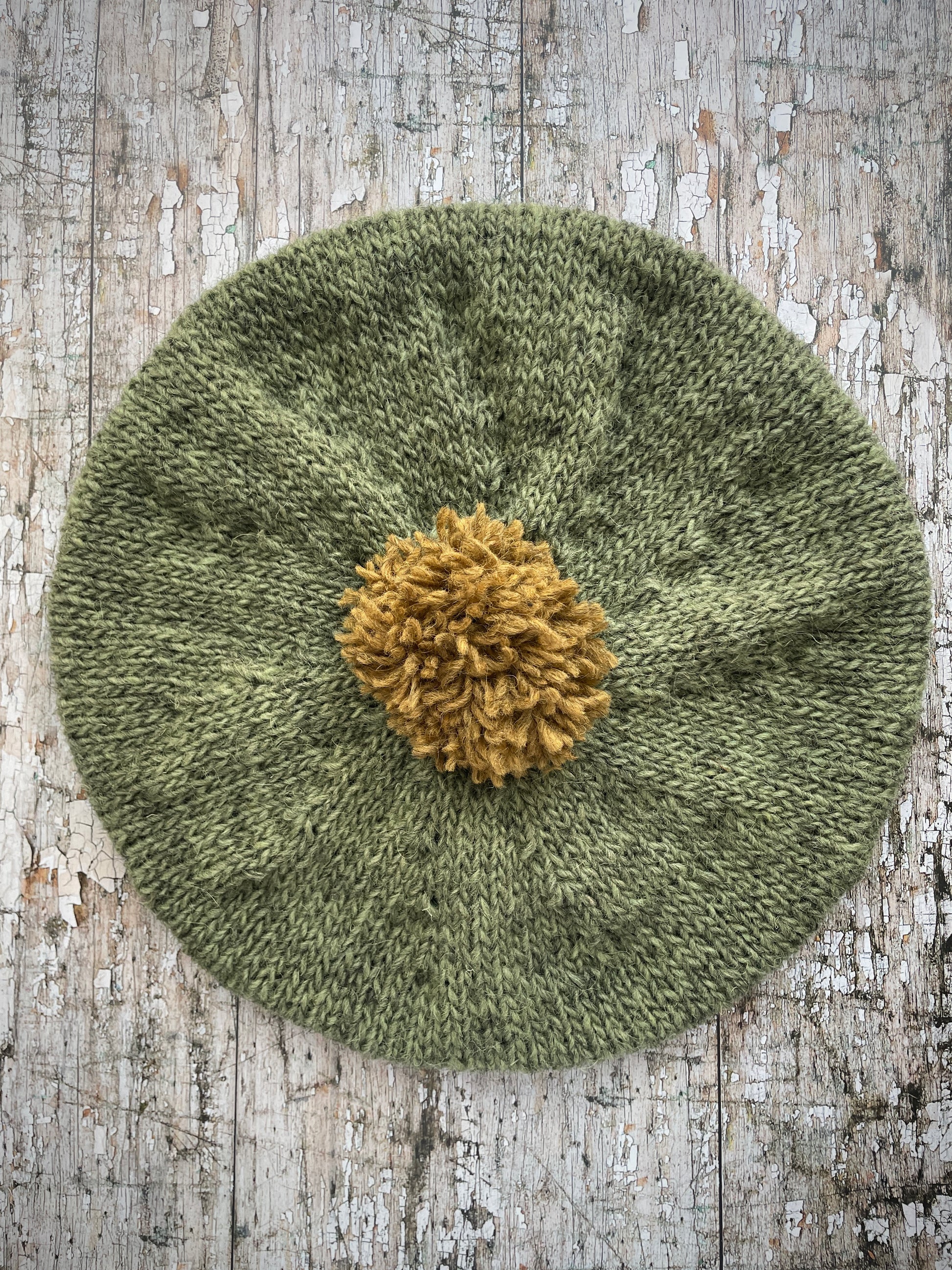 Hand Knitted Wool Beret Olive + Dark Kelp

Beautifully hand knitted beret in Icelandic pure wool, perfect for keeping your head warm on cold days, knitted in olive with a dark kelp colour pom and ribbed band that gives the hat a snug fit.

SIZE: adult.

DIAMETER: 11+1/2" / 29.5 cm.

CARE: hand wash or machine wash on wool cycle at 30 degrees, dry flat, do not tumble dry.