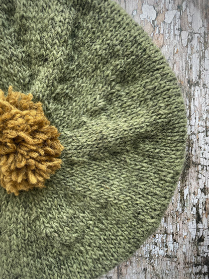 Hand Knitted Wool Beret Olive + Dark Kelp

Beautifully hand knitted beret in Icelandic pure wool, perfect for keeping your head warm on cold days, knitted in olive with a dark kelp colour pom and ribbed band that gives the hat a snug fit.

SIZE: adult.

DIAMETER: 11+1/2" / 29.5 cm.

CARE: hand wash or machine wash on wool cycle at 30 degrees, dry flat, do not tumble dry.