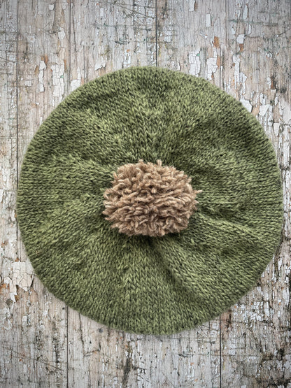Hand Knitted Wool Beret Olive + Dark Oat

Beautifully hand knitted beret in Icelandic pure wool, perfect for keeping your head warm on cold days, knitted in olive with a dark oat colour pom and ribbed band that gives the hat a snug fit.

SIZE: adult.

DIAMETER: 11" / 28 cm.

CARE: hand wash or machine wash on wool cycle at 30 degrees, dry flat, do not tumble dry.