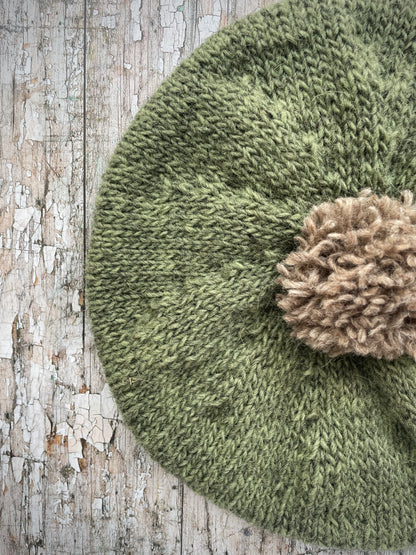 Hand Knitted Wool Beret Olive + Dark Oat

Beautifully hand knitted beret in Icelandic pure wool, perfect for keeping your head warm on cold days, knitted in olive with a dark oat colour pom and ribbed band that gives the hat a snug fit.

SIZE: adult.

DIAMETER: 11" / 28 cm.

CARE: hand wash or machine wash on wool cycle at 30 degrees, dry flat, do not tumble dry.