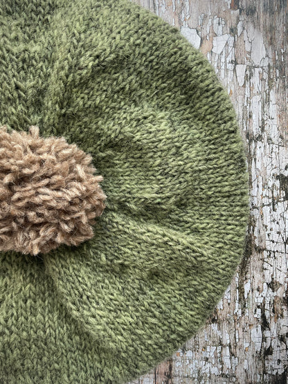 Hand Knitted Wool Beret Olive + Dark Oat

Beautifully hand knitted beret in Icelandic pure wool, perfect for keeping your head warm on cold days, knitted in olive with a dark oat colour pom and ribbed band that gives the hat a snug fit.

SIZE: adult.

DIAMETER: 11" / 28 cm.

CARE: hand wash or machine wash on wool cycle at 30 degrees, dry flat, do not tumble dry.