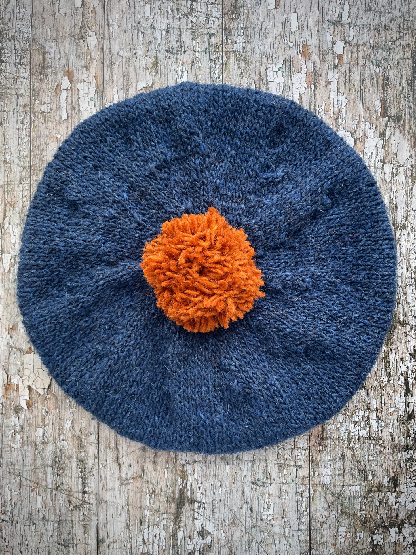 Hand Knitted Wool Beret Indigo Blue + Burnt Orange

Beautifully hand knitted beret in Icelandic pure wool, perfect for keeping your head warm on cold days, knitted in indigo with a burnt orange colour pom and ribbed band that gives the hat a snug fit.

SIZE: adult.

DIAMETER: 11+1/4" / 28 cm.

CARE: hand wash or machine wash on wool cycle at 30 degrees, dry flat, do not tumble dry.