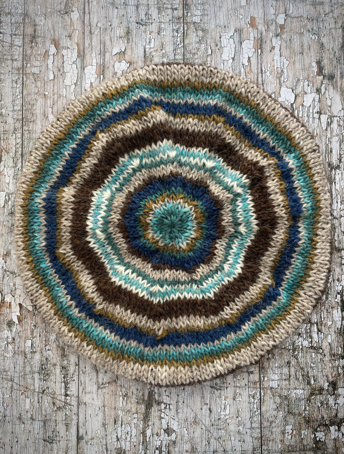 Classic 40's Style Beret no.14
Beautifully hand knitted beret in Icelandic wool, perfect for keeping your head warm on cold days and adding a touch of 40's style to any outfit. Knitted in dark chocolate brown, indigo blue, oat, white, aqua heather, dark kelp and viridian stripes, with a dark chocolate brown ribbed band that gives the hat a snug fit.

SIZE: adult.

DIAMETER: 11+1/4" / 28.5cm.

CARE: hand wash or machine wash on wool cycle at 30 degrees, dry flat, do not tumble dry.