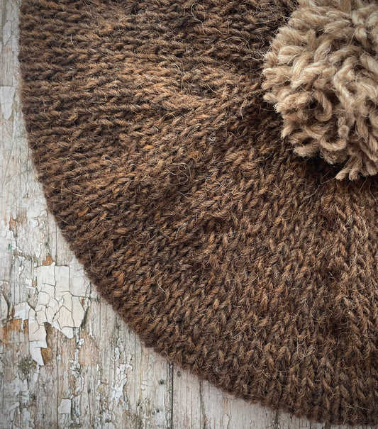 Hand Knitted Wool Beret Dark Chocolate + Dark Oat

Beautifully hand knitted beret in Icelandic pure wool, perfect for keeping your head warm on cold days. Knitted in a lovely dark chocolate brown colour with a dark oat pom and ribbed band that gives the hat a snug fit.

SIZE: adult.

DIAMETER: 11+1/2" / 29cm.

CARE: hand wash or machine wash on wool cycle at 30 degrees, dry flat, do not tumble dry.